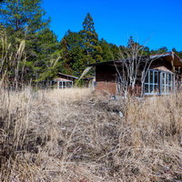 青空の下に佇むボロボロの廃コテージ。朽ちた古い小屋の写真