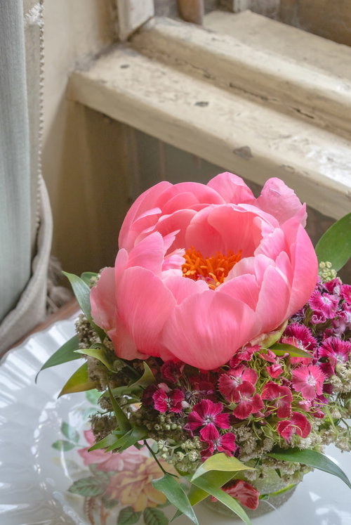 窓辺に置かれたピンクの芍薬を使ったフラワーアレンジメント