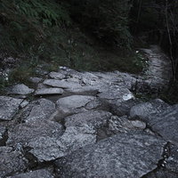 急な神倉神社の石段と岩場の階段を登る参拝者の道のりの写真