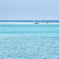 干潮時だけに姿を現す幻の浜辺に上陸する白い船の写真