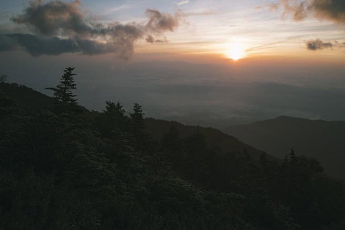 鳳凰三山の山肌に差し掛かるご来光と朝焼けの風景