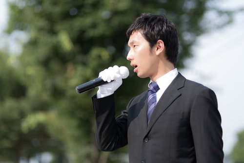 街頭演説でマイクを握り政策を訴える若手議員