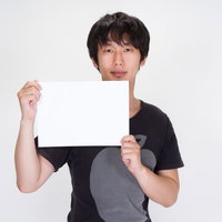 ホワイトボードを持つカメラアシスタントの男性の写真