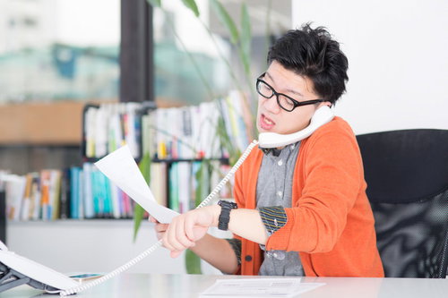 出来上がった原稿を手配するオペレーター男性