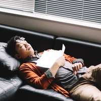 ソファの上で死んだように眠る社畜の写真