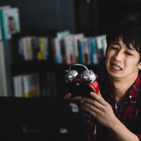 出勤72時間後、疲れ切った表情の男性の労働過多の実態の写真