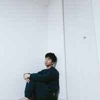 薬を飲もうとするスーツ姿の男性の写真