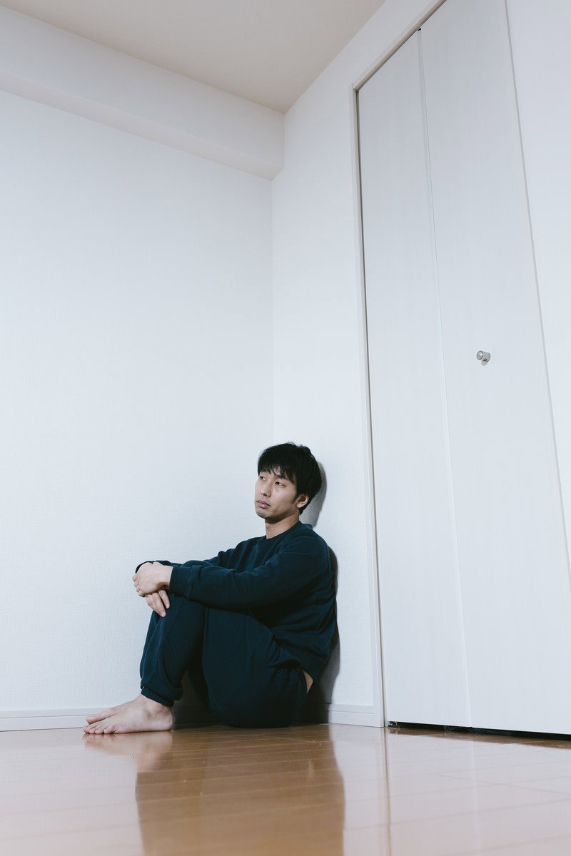 薬を飲もうとするスーツ姿の男性［モデル：大川竜弥］