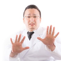 医者もドン引き！両手を上げて制止する白衣姿の男性の写真