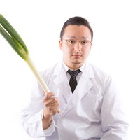 風邪予防には葱でしょと白衣の医者が持つ長葱の写真