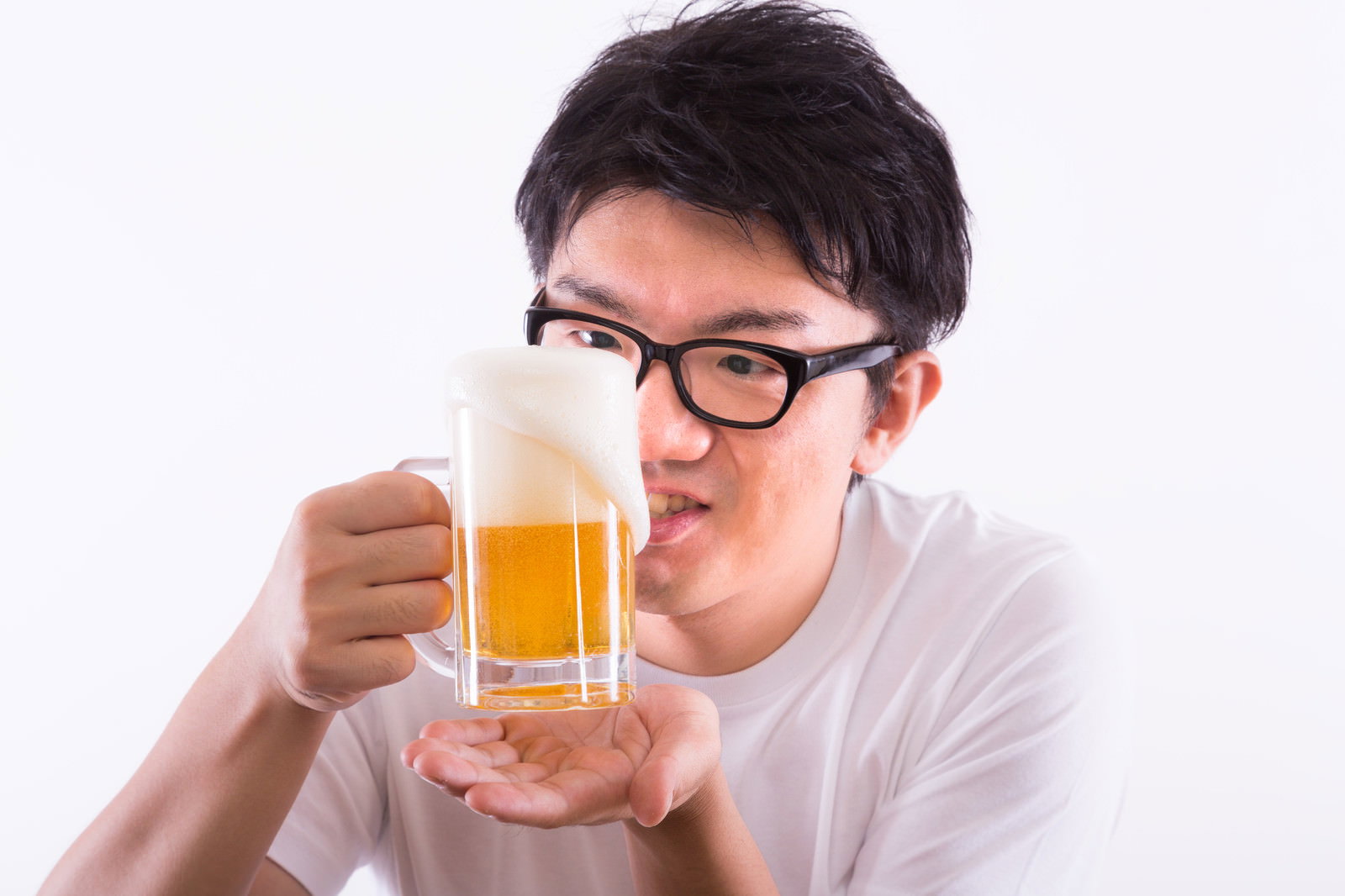 泡が溢れる生ビールをジョッキに注ぐ眼鏡の男性［モデル：OZPA］