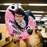就業後に浮き輪を持ってオフィスから飛び出すエンジニアの写真
