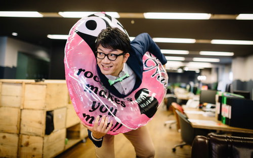 就業後に浮き輪を持ってオフィスから飛び出すエンジニア