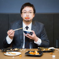 食べ方が汚いビジネスマンは社畜の象徴、コンビニ弁当を机で散らかしながら食べるの写真