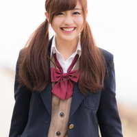 紺色制服姿で笑顔を見せる女子高生のポートレートの写真