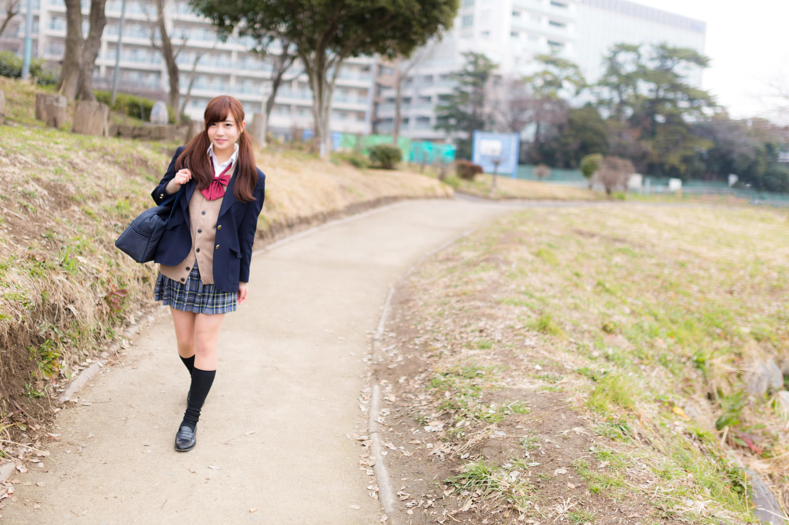 ブレザー姿でスクールバッグを持ち下校路を歩く女子高生［モデル：河村友歌］