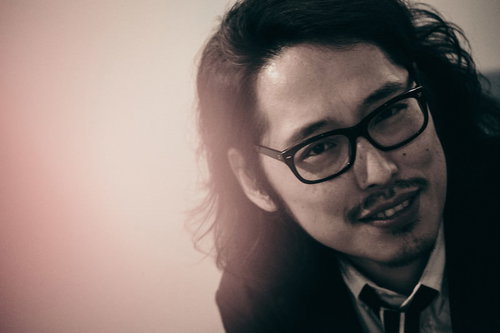 敏腕プロデューサーのオフショット、眼鏡姿で笑顔の男性