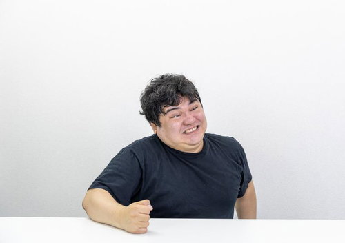 黒Tシャツ姿で歯を食いしばり台パンする男性