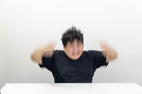 こちらを向いて大きく叫ぶ男性の感情表現