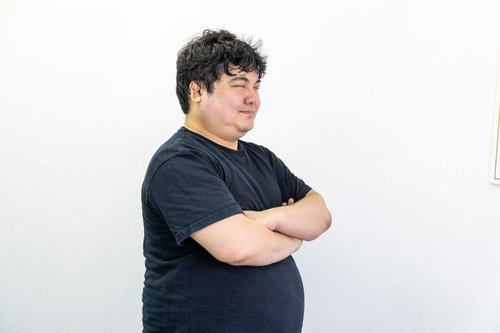 黒Tシャツで腕組みポーズをする男性のポートレート