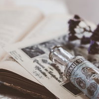 古い瓶と洋書、ドライフラワーが並ぶ書斎の魔法的な雰囲気の写真