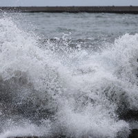 防波堤の消波ブロックに打ち付ける荒波と飛沫の写真