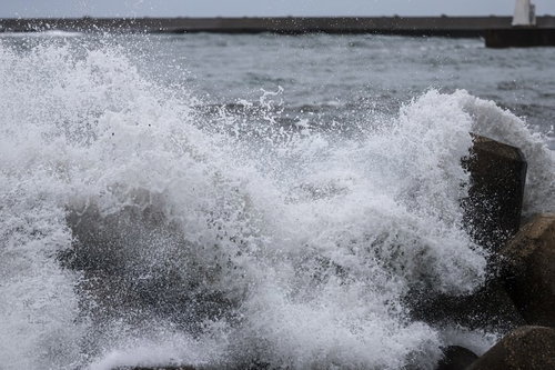 防波堤の消波ブロックに打ち付ける荒波と飛沫