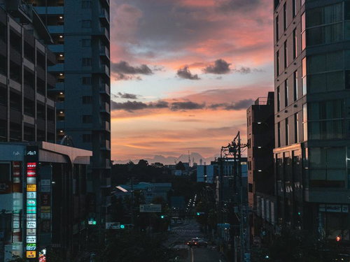 夕焼けに染まる駅前の街並み。高層ビルと夕方の空