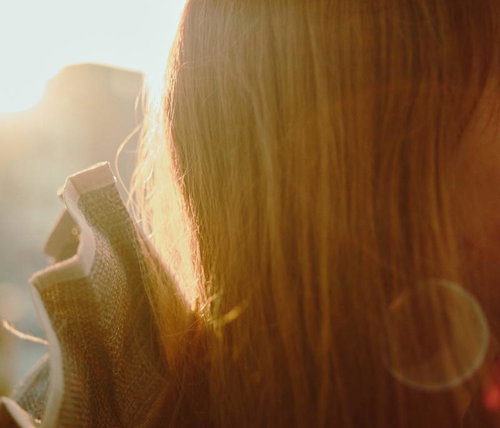 夕陽があたる女性の後ろ姿と長い髪、黄金色に輝くロングヘア