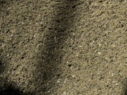 影が伸びるアスファルト壁のテクスチャー