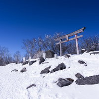 雪に覆われた赤城山山頂の神社鳥居と冬景色の写真