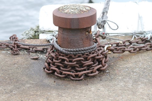 船着き場に錆び付く鎖が巻き付くボラード、係船柱の風景