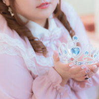 ティアラを両手に持った姫風の女性、ツインテールドレス姿の写真