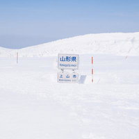 山形県上山市の蔵王雪山に立つ山形県と宮城県の県境看板の写真