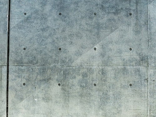 コンクリート打ちっぱなし壁に斜めに残る黒い筋状の跡