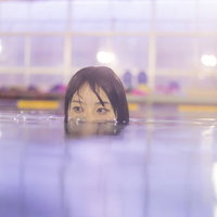 プールの水面からのぞく女性の写真