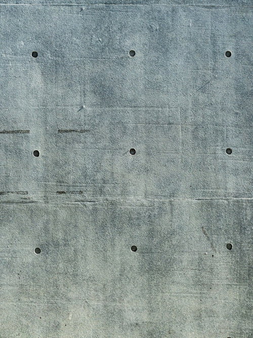 深めのセパ穴が規則正しく配置されたコンクリート打ちっぱなし壁