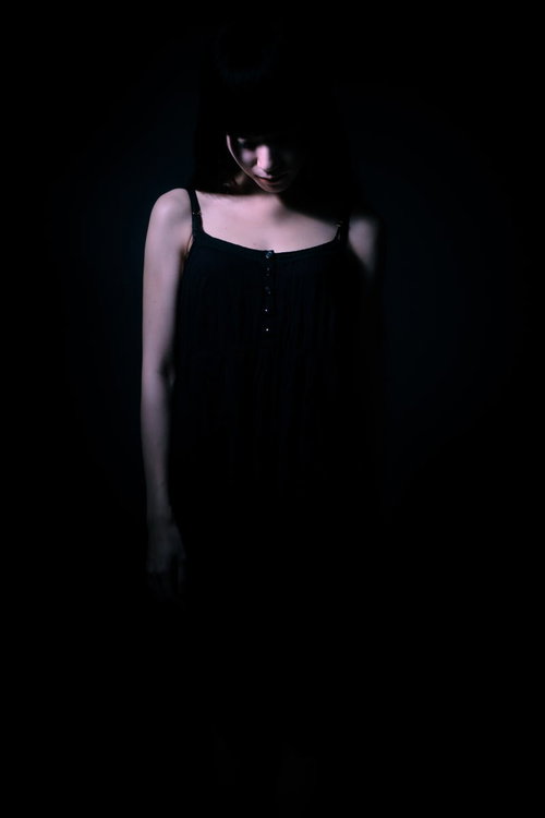 暗闇で独りになって悲しくなる女性のシルエット