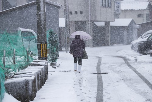 降雪の道路に残る足跡とタイヤ痕の冬景色と積雪風景