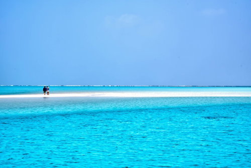 与論島の百合ヶ浜に立つ観光客の南国風景と透明な海