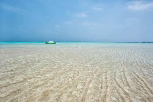 干潮時に百合ヶ浜に近づくボート、与論島の透明度の高い海