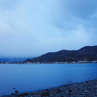 琵琶湖湖畔で迎える静かな夜明けの景色と朝焼けの水面の写真