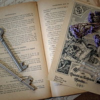 魔法使いの机に広げられた古書と鍵、ドライフラワーの物語の写真