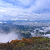 磐梯山の山頂から眺める会津若松の街並みと飯豊山の写真