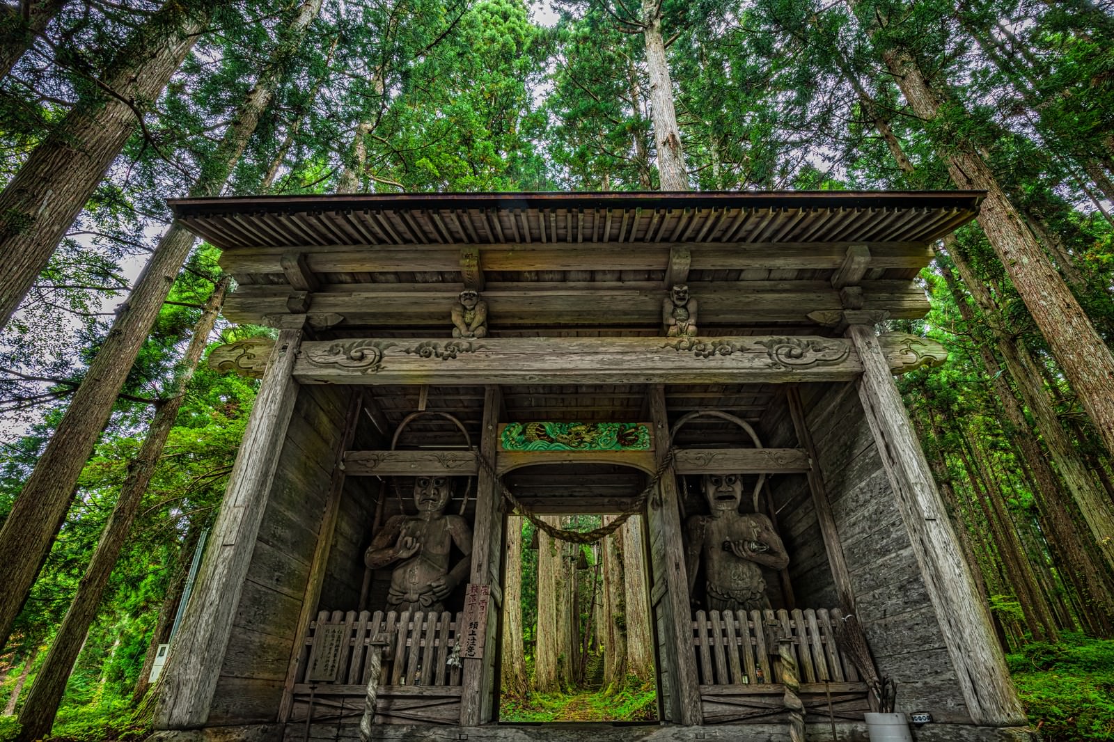 緑深い森の中に立つ金峰神社の古い木造仁王門
