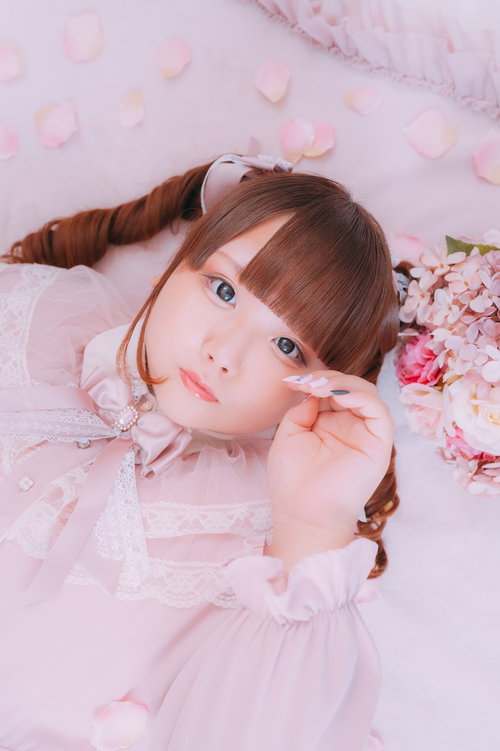 ピンクの花に囲まれて横になるぽちゃかわ女子