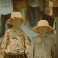 麦わら帽子を被った兄妹のマネキン、恐竜柄の子供服姿の写真