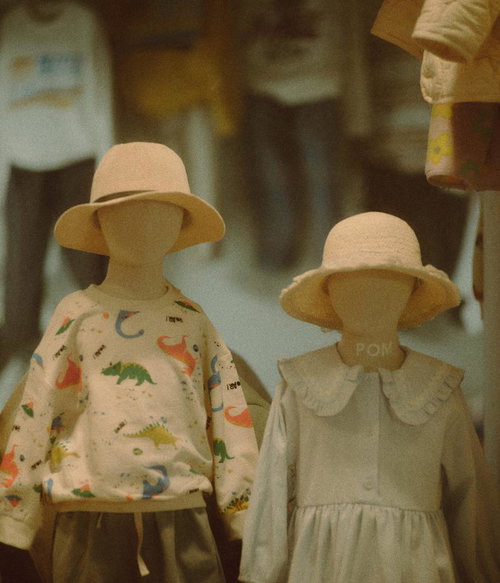 麦わら帽子を被った兄妹のマネキン、恐竜柄の子供服姿