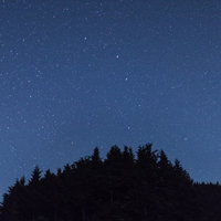 鏡野町笠菅峠からの夜空に映る星々と流星、山のシルエットの写真