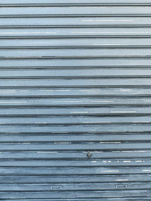 長年使われてきた青いシャッターの建具の金属テクスチャー